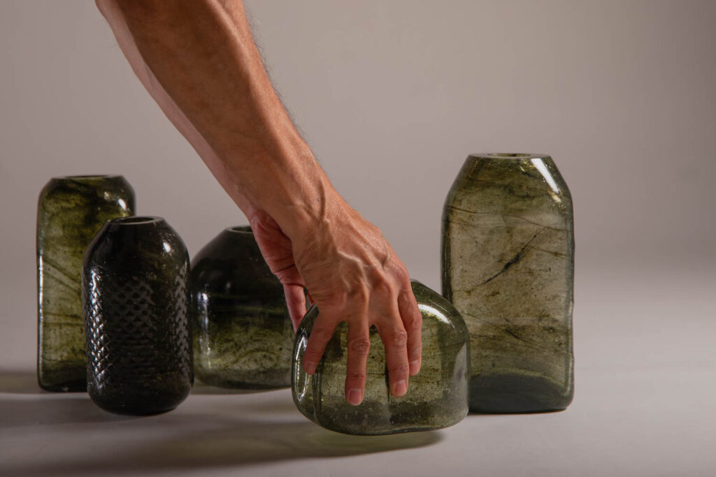 a hand reaching for glass vessels