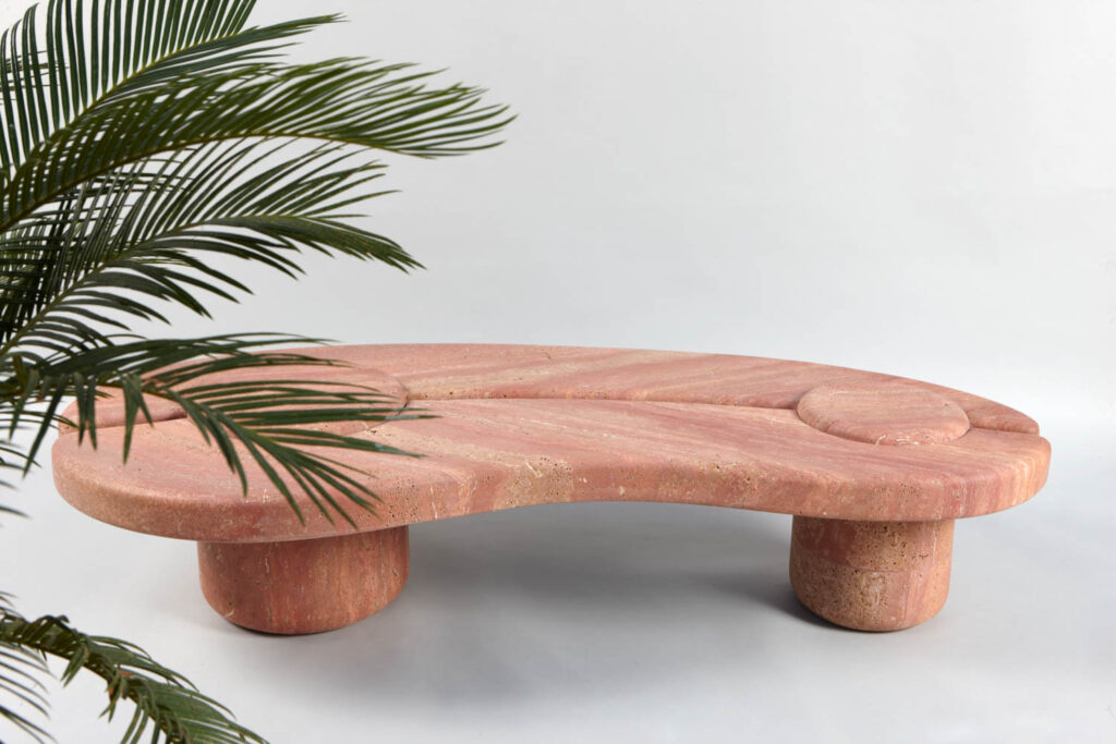 a curved table with palm leaf nearby