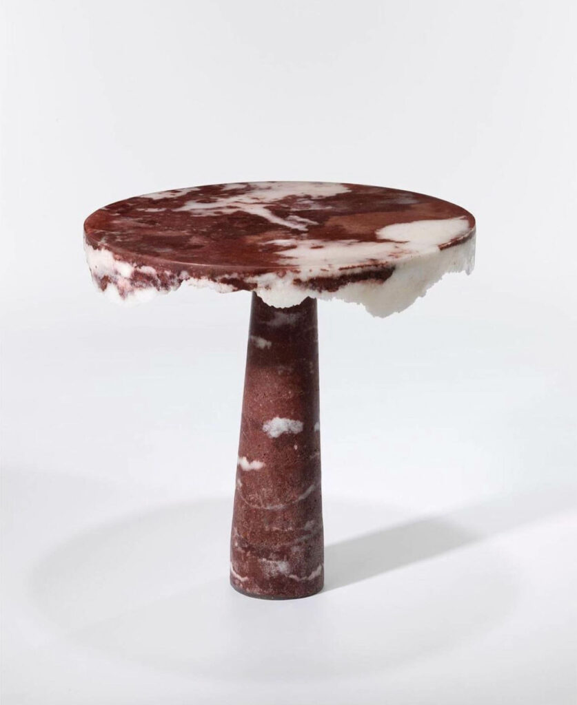 a pedestal table in burgundy and white marble top