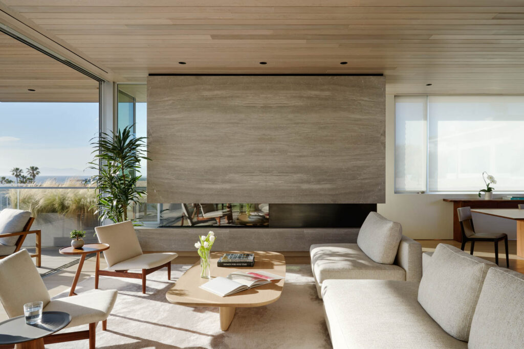 a living room fireplace clad with acid-blasted silver travertine