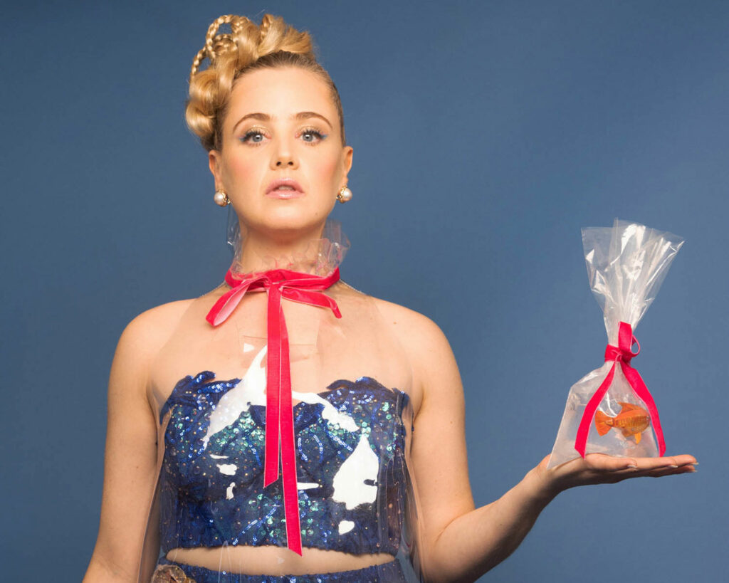 liz toonkel holding a goldfish and wearing a blue dress