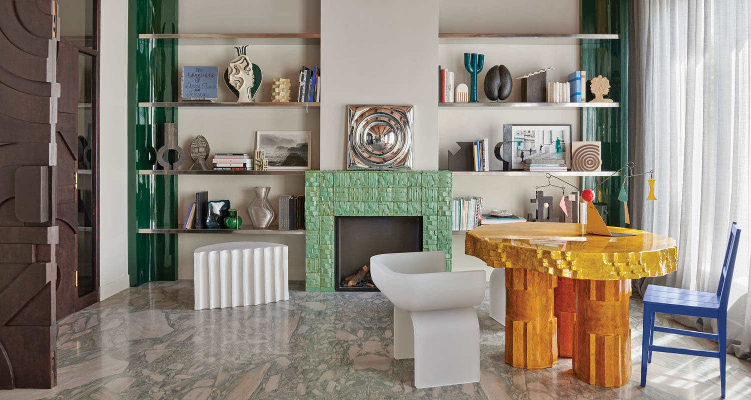 a bright living room with an orange table and two chairs