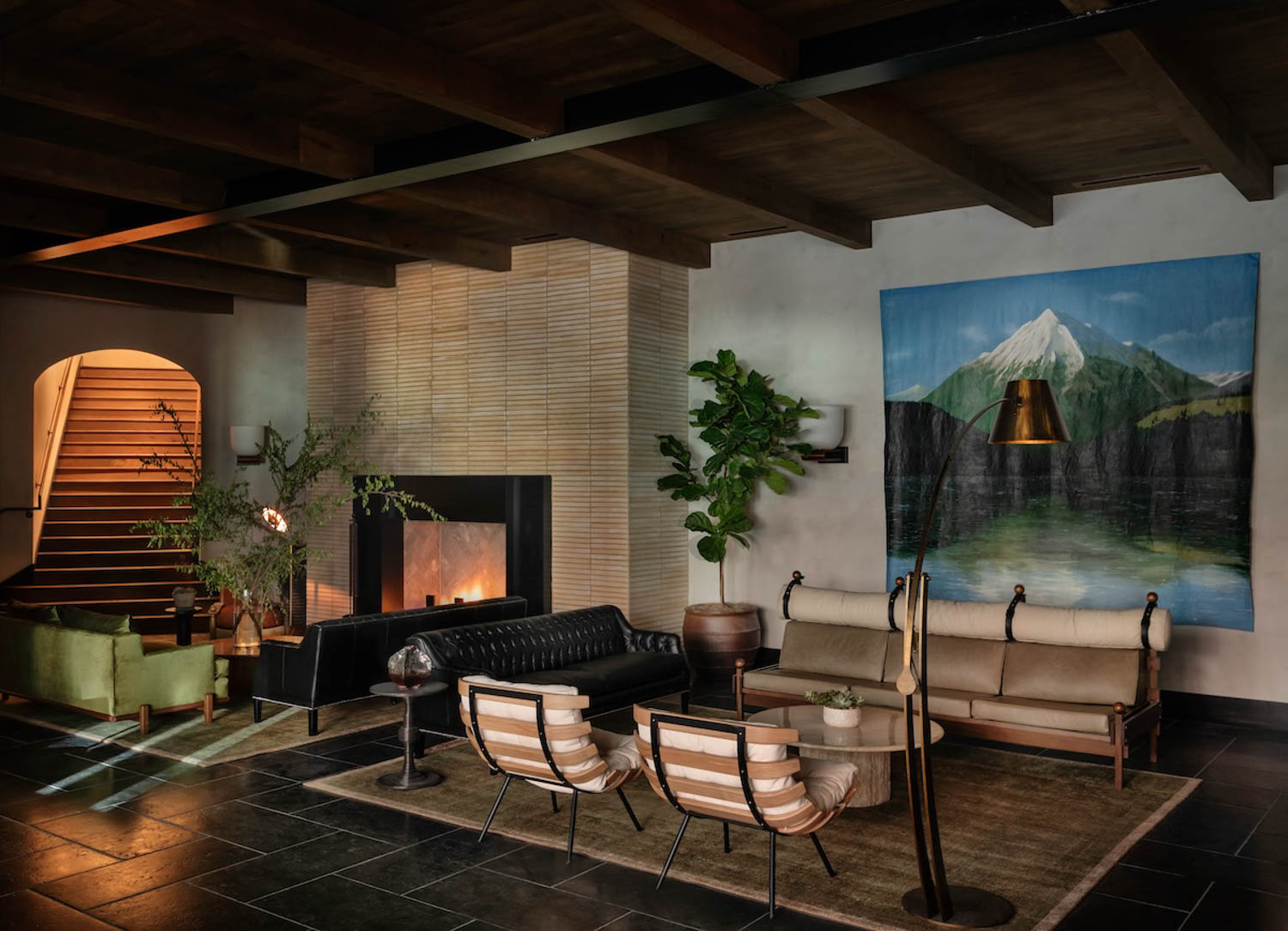 hotel lobby with mountain artwork, fireplace and dim lighting