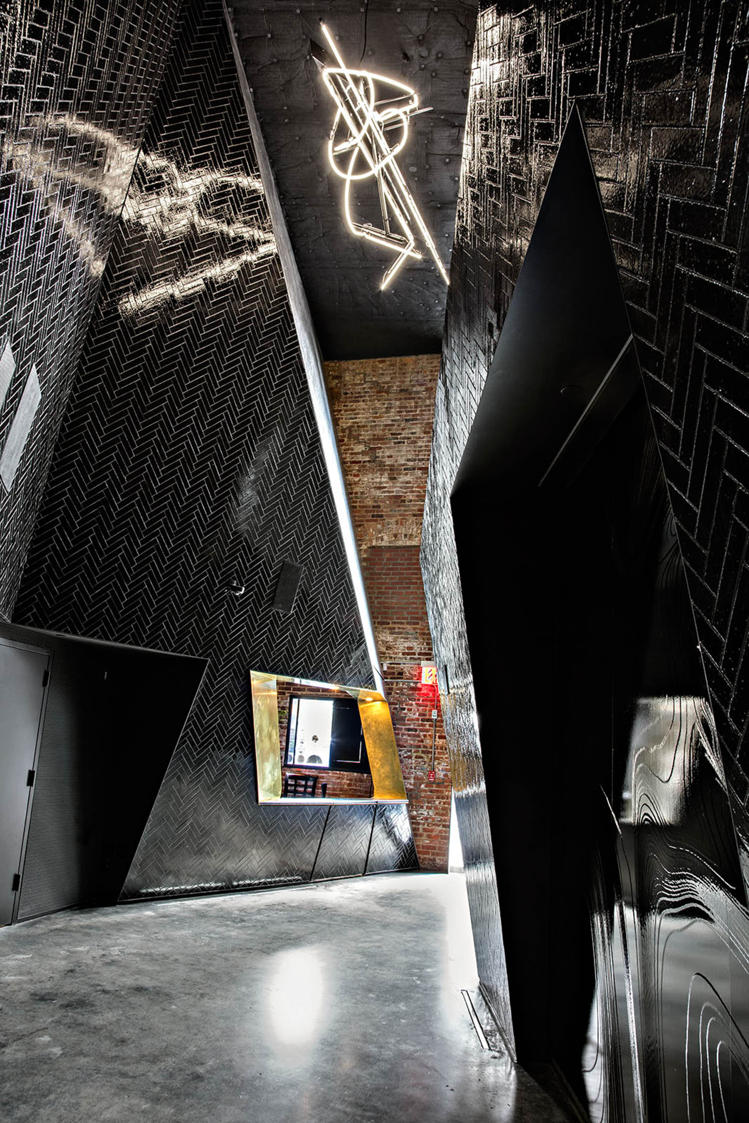 room with tall black panels and concrete flooring