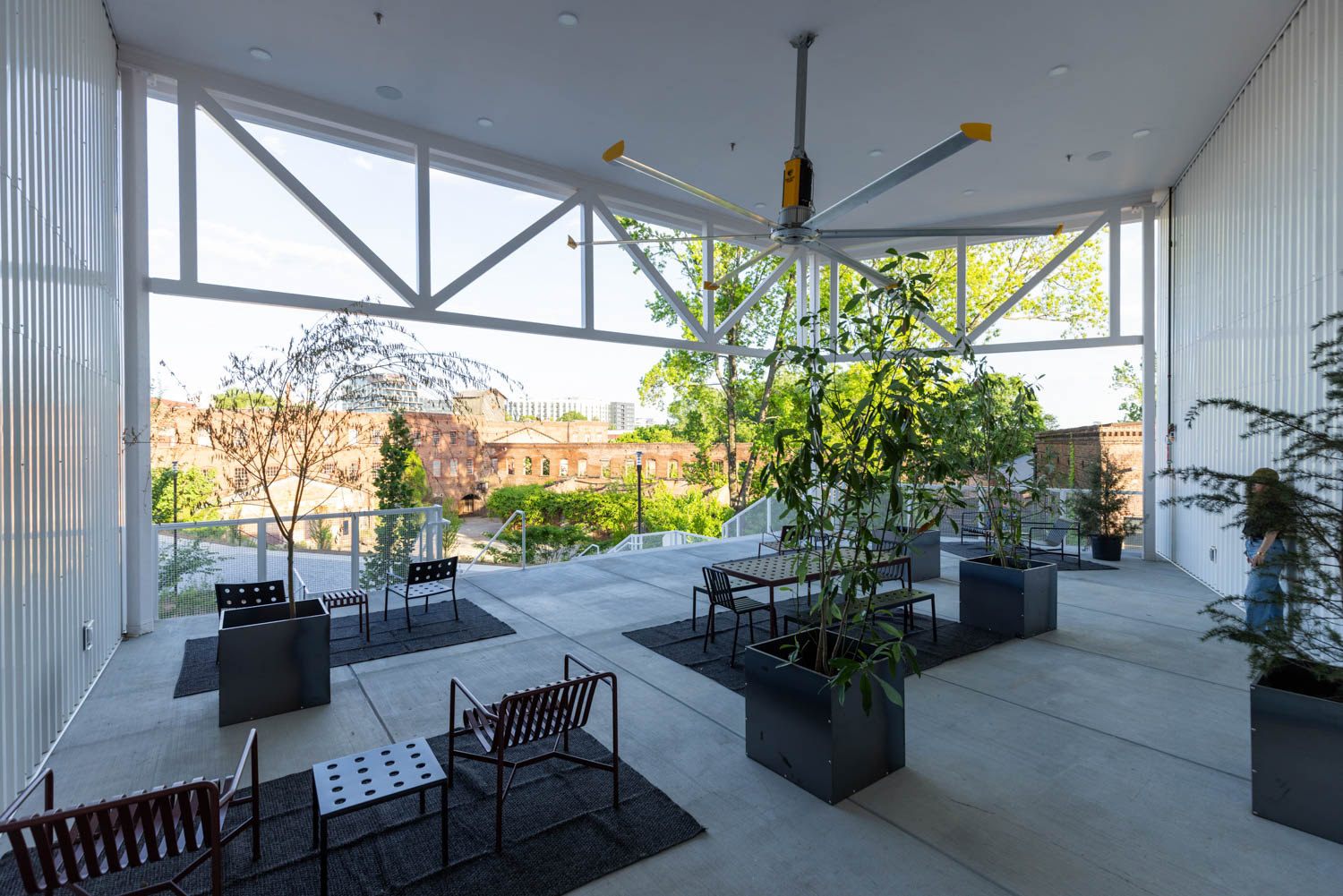 outdoor patio area with multiple black chairs and large lighting fixture