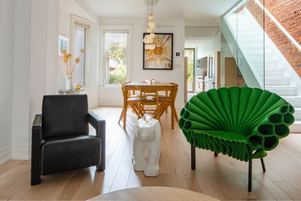 view to the dining area with black chair, polar bear table and peacock green chair