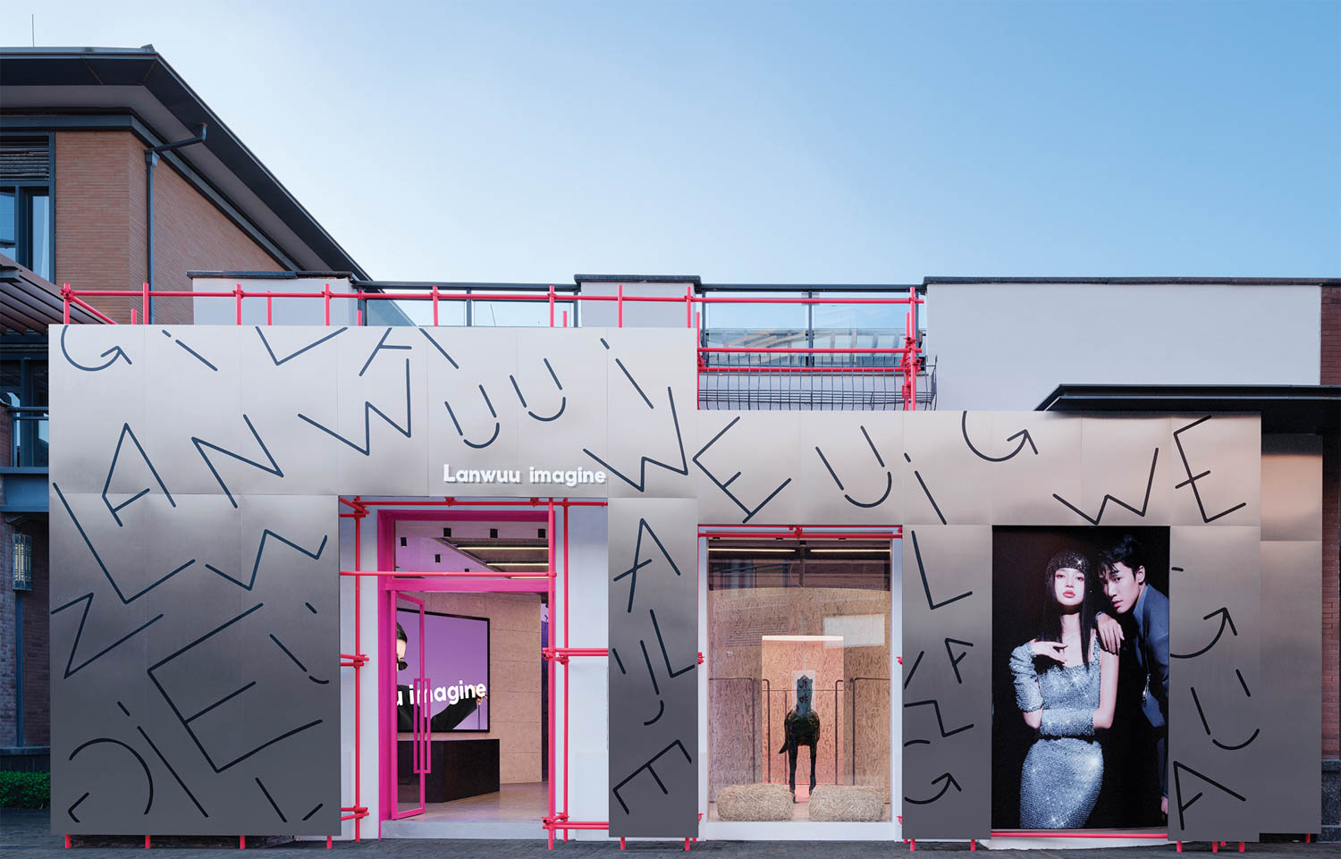 entrance facade with pink scaffolding and stainless-steel screen