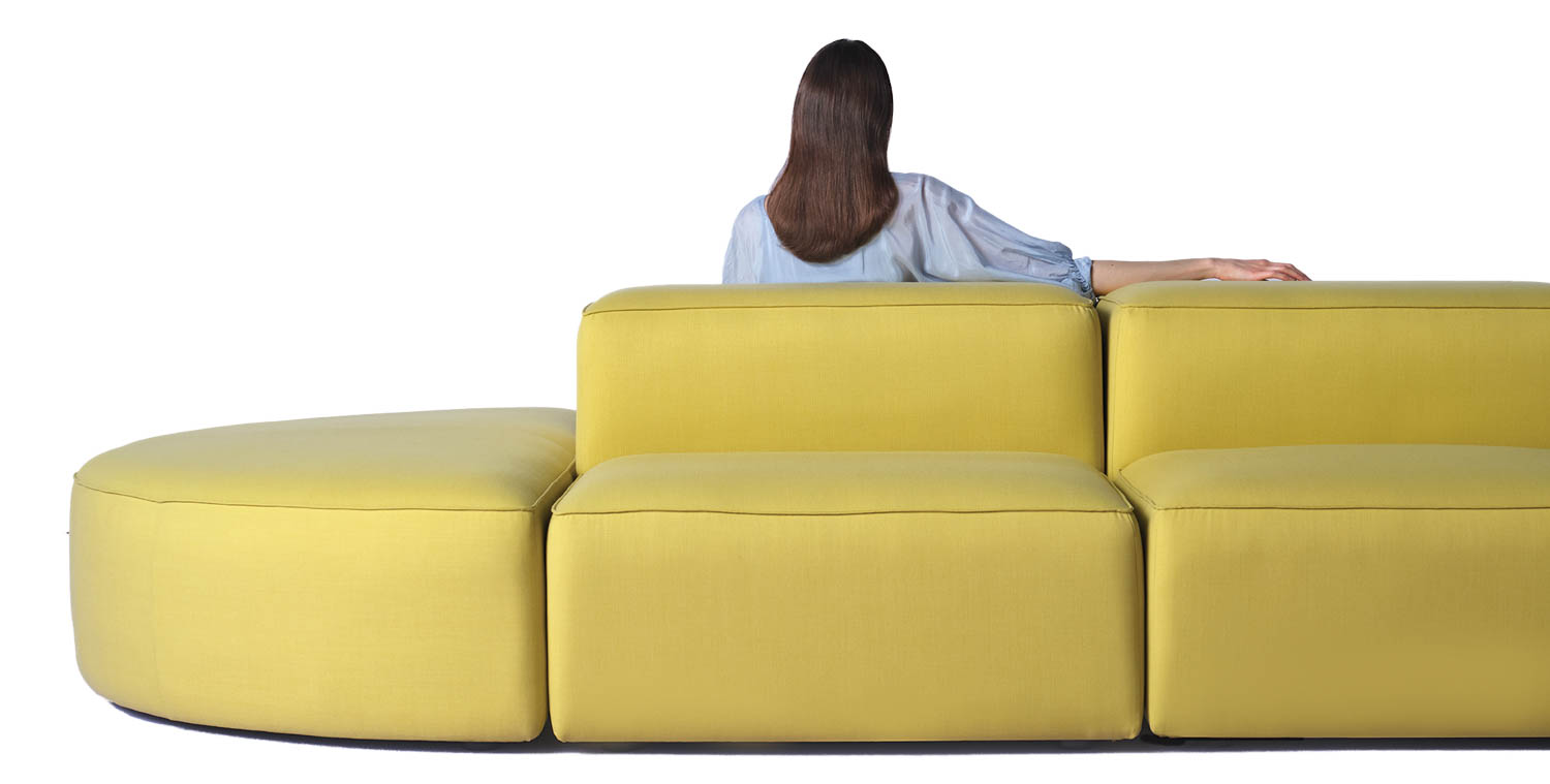 woman sitting on modular yellow sofa