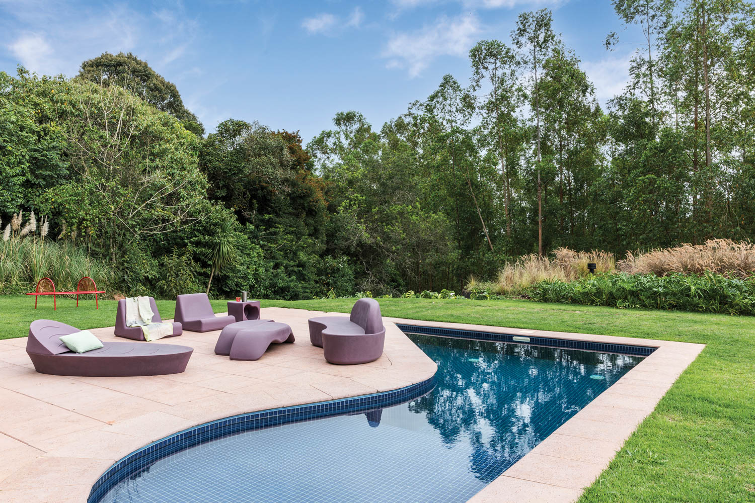 swimming pool with lavender seating vignette amidst the grassy landscape