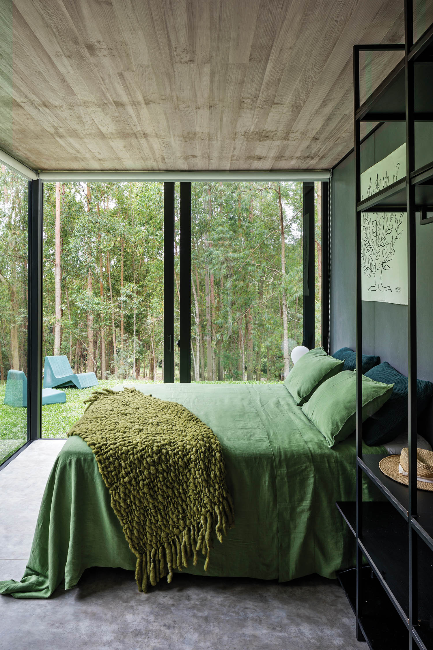 main bedroom with glass-wall module and green sheets