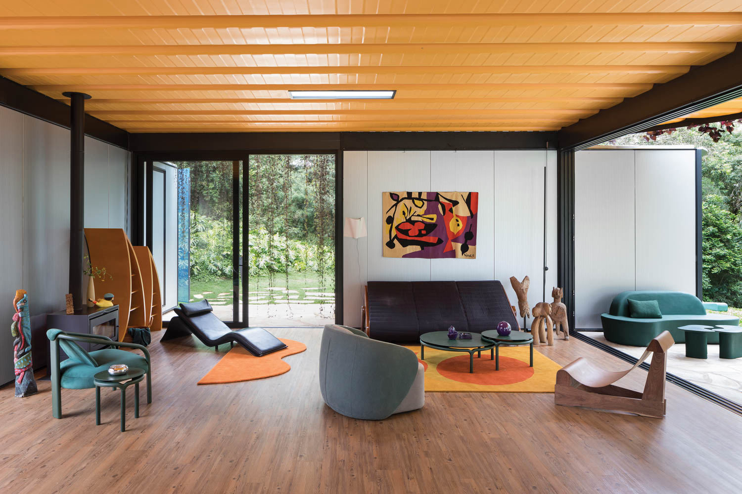 living room with colorful artwork, bright yellow ceiling and grey sling chair