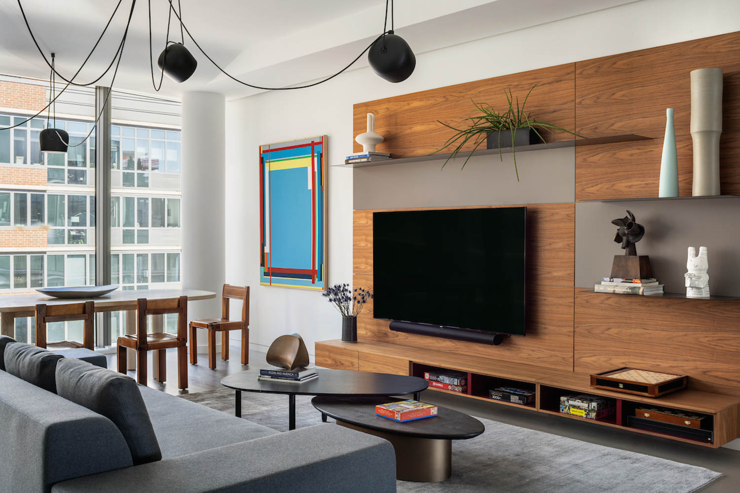 black chandelier hanging over a wooden wall unit and sofa