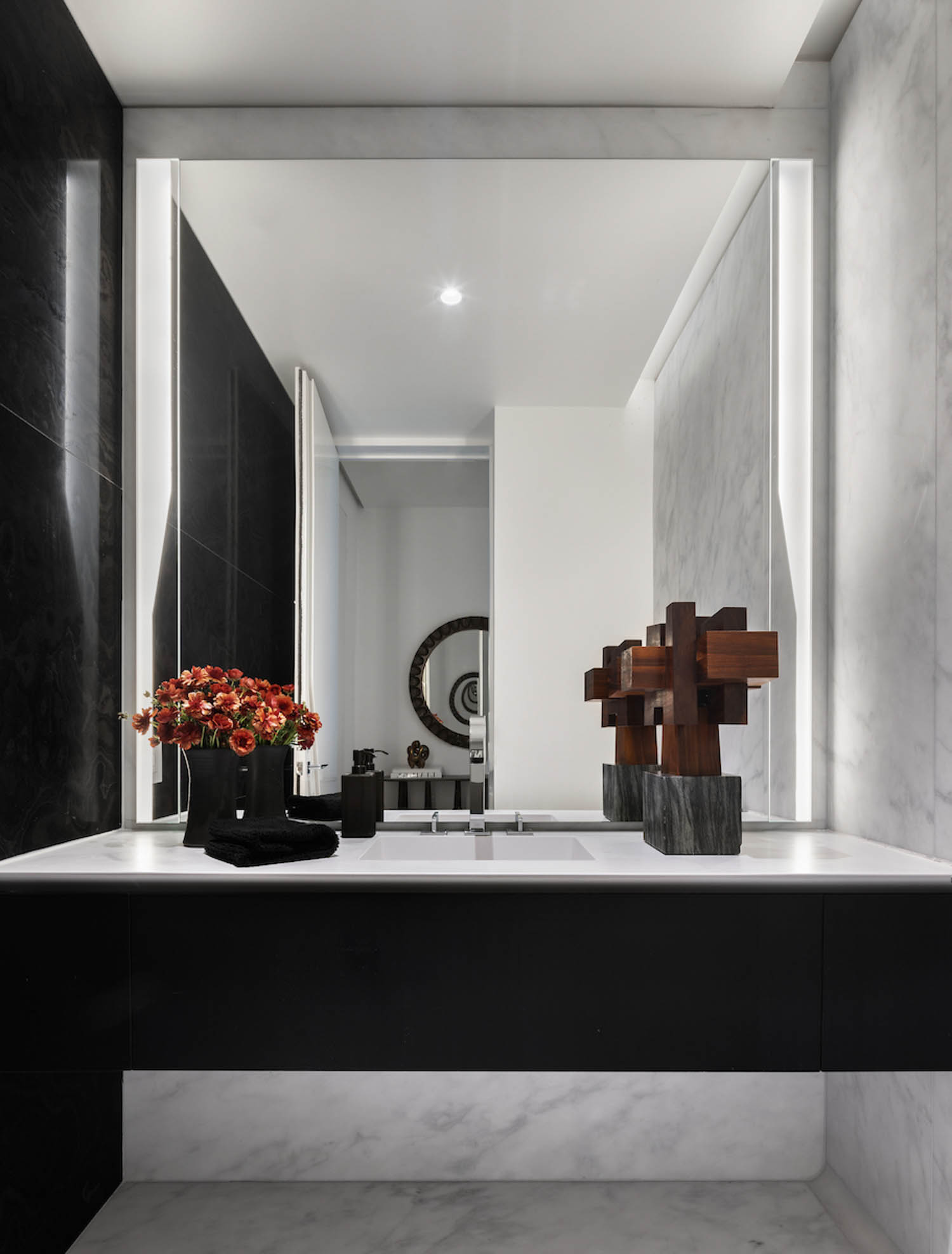 second bathroom with black vanity, mirror and flowers