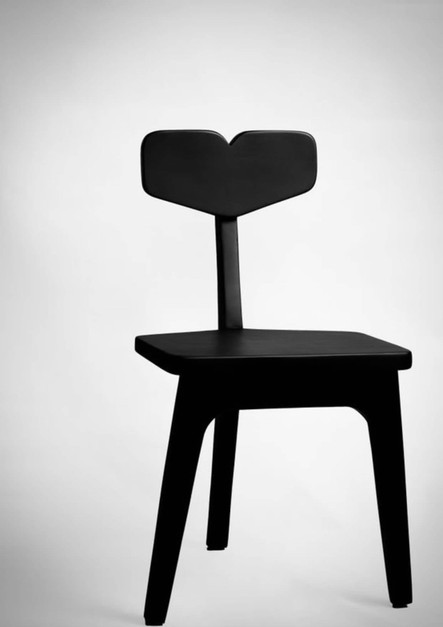 lanky black chair with three legs