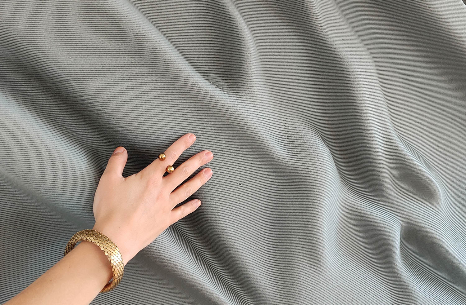 hand next to dark grey fabric