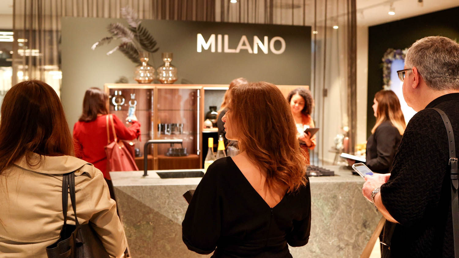 people standing in the showroom in front of the Milano area