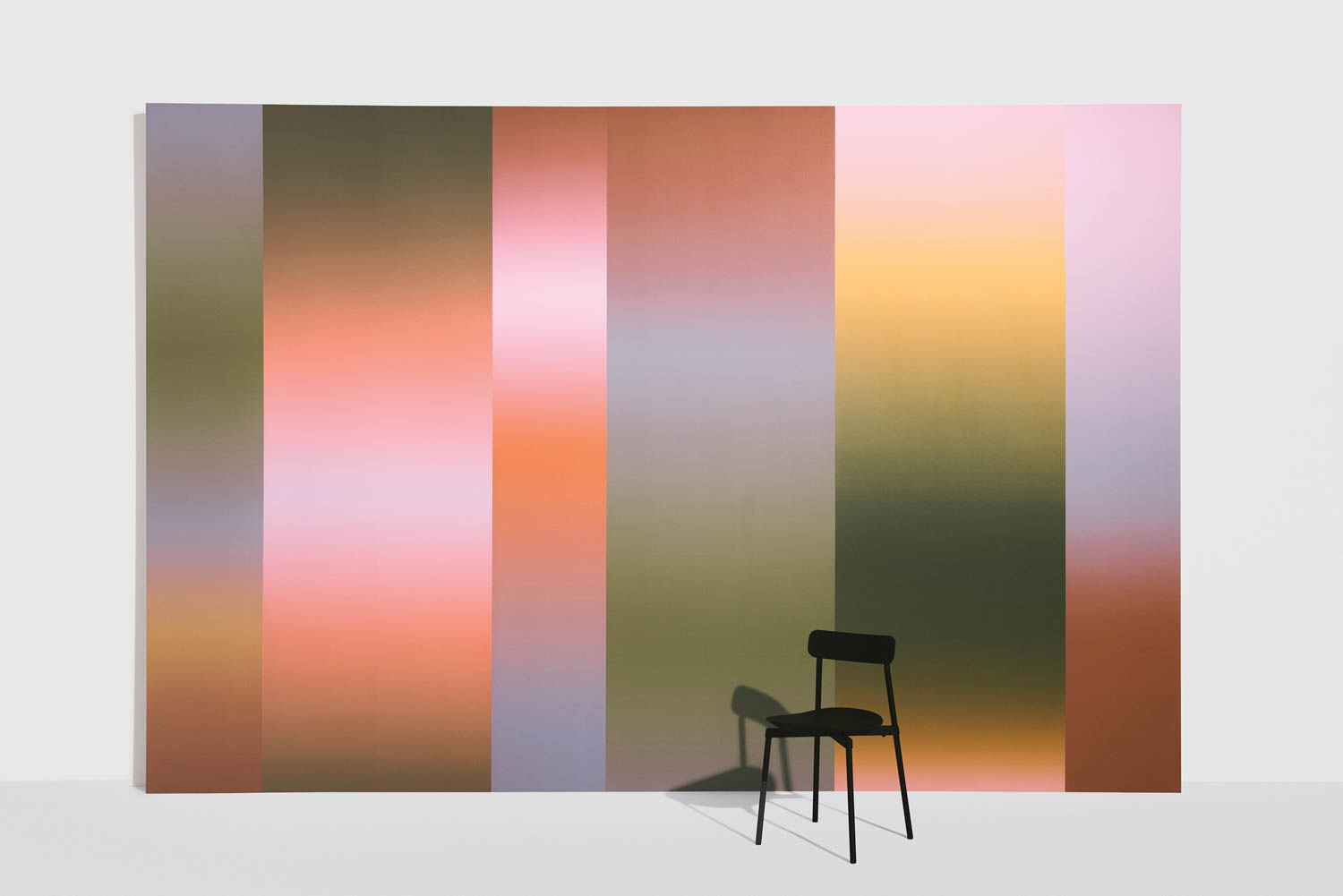 multicolored wallpaper with a black chair in front