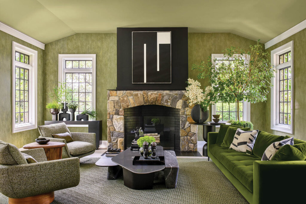 the den includes a fireplace and green walls and accents