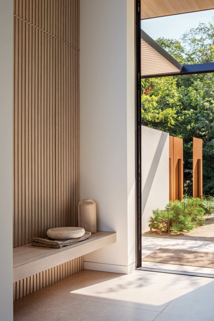 resting bench in front of a slatted wall in the entry foyer