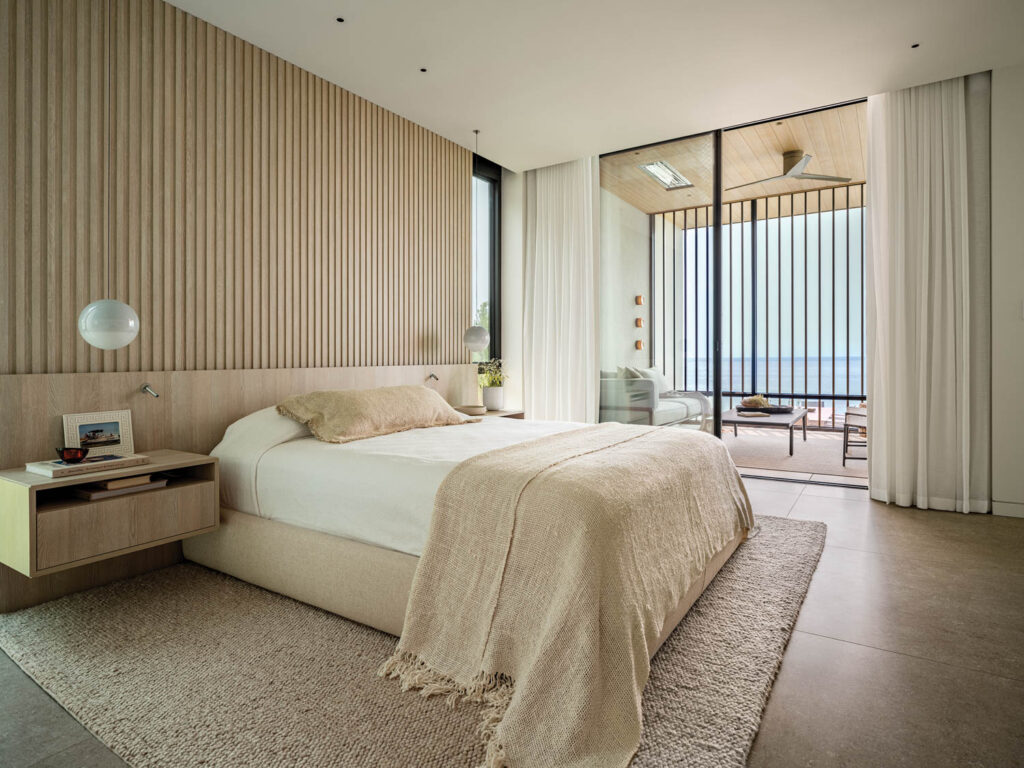 white bedroom with slatted walls and a screened porch