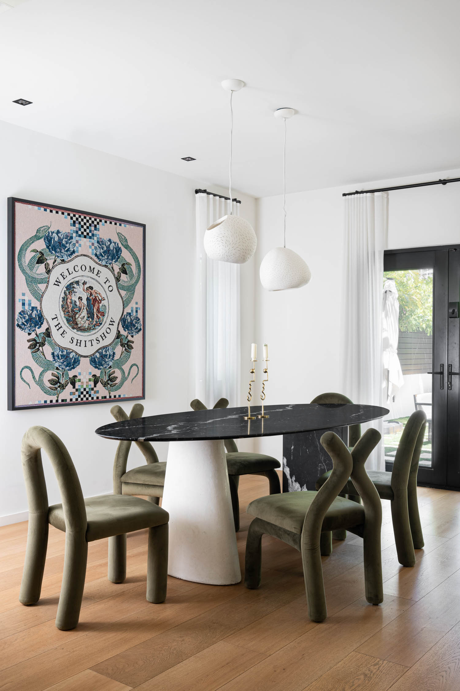 dining area with olive green chairs, artwork and black and white table