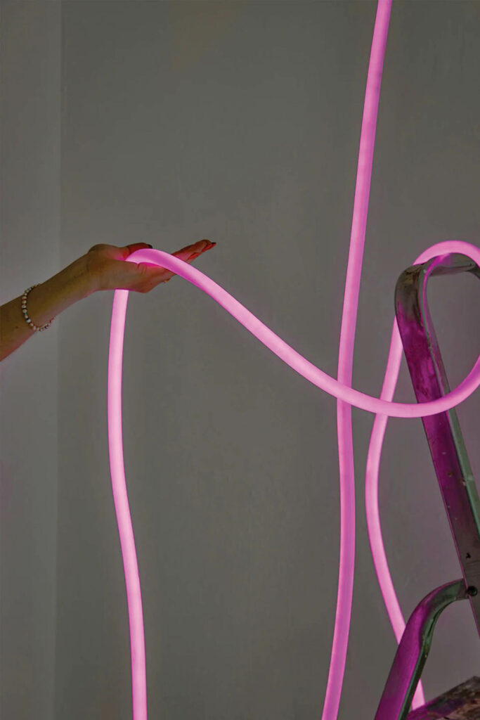 hand holding neon pink light strands