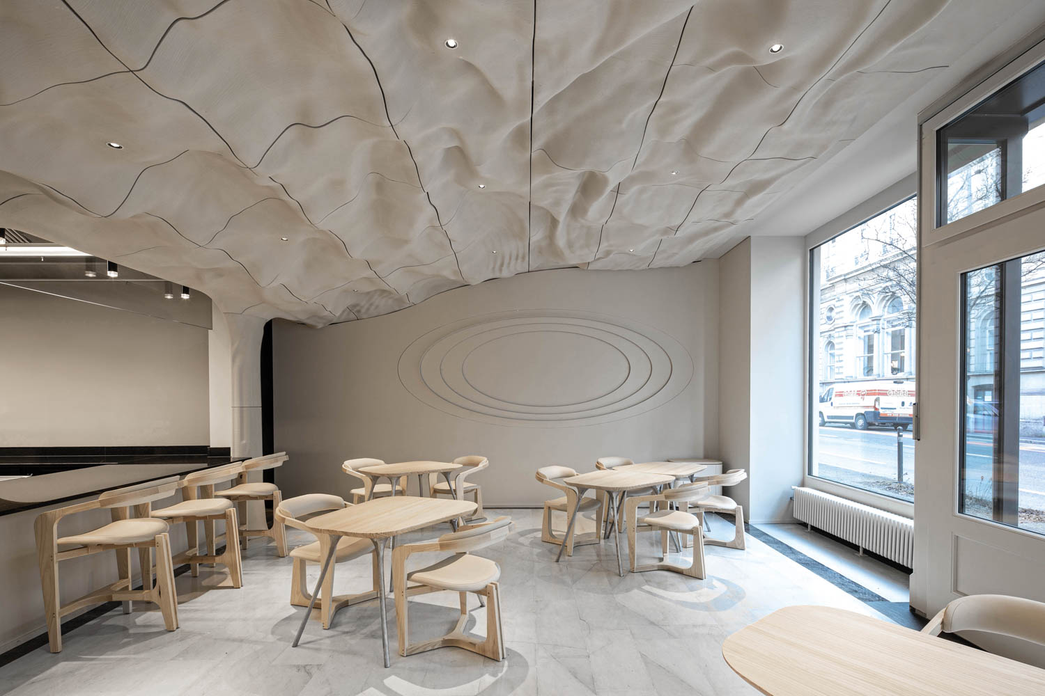 all white dining area with wooden tables and rock ceiling