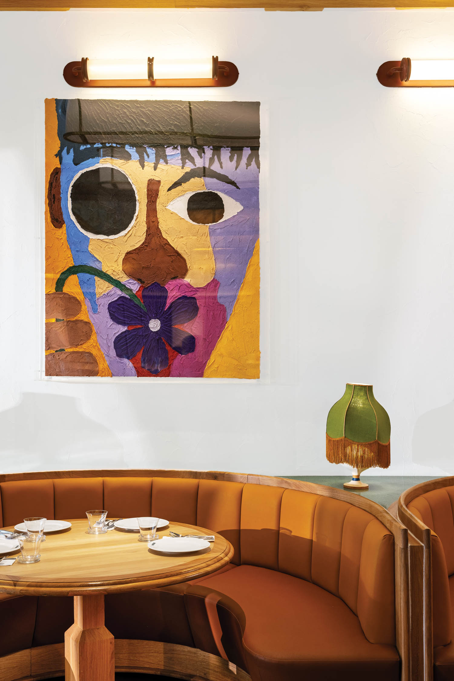 closeup of curved banquette and abstract art