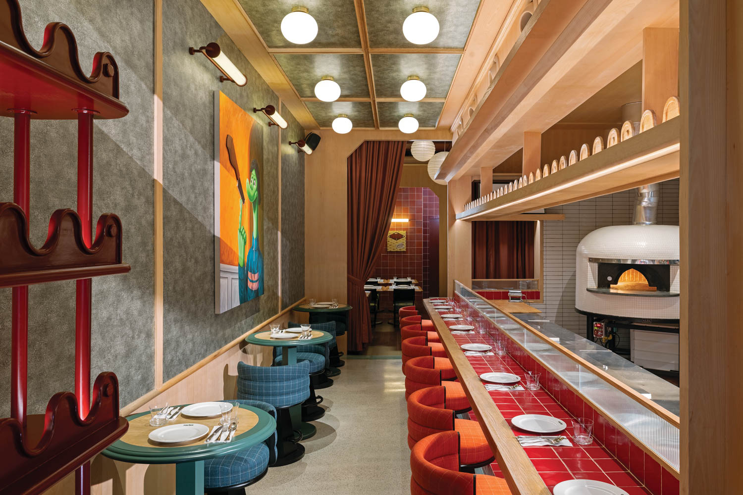 seating area with red bar and chair and round tables with blue edges and chairs