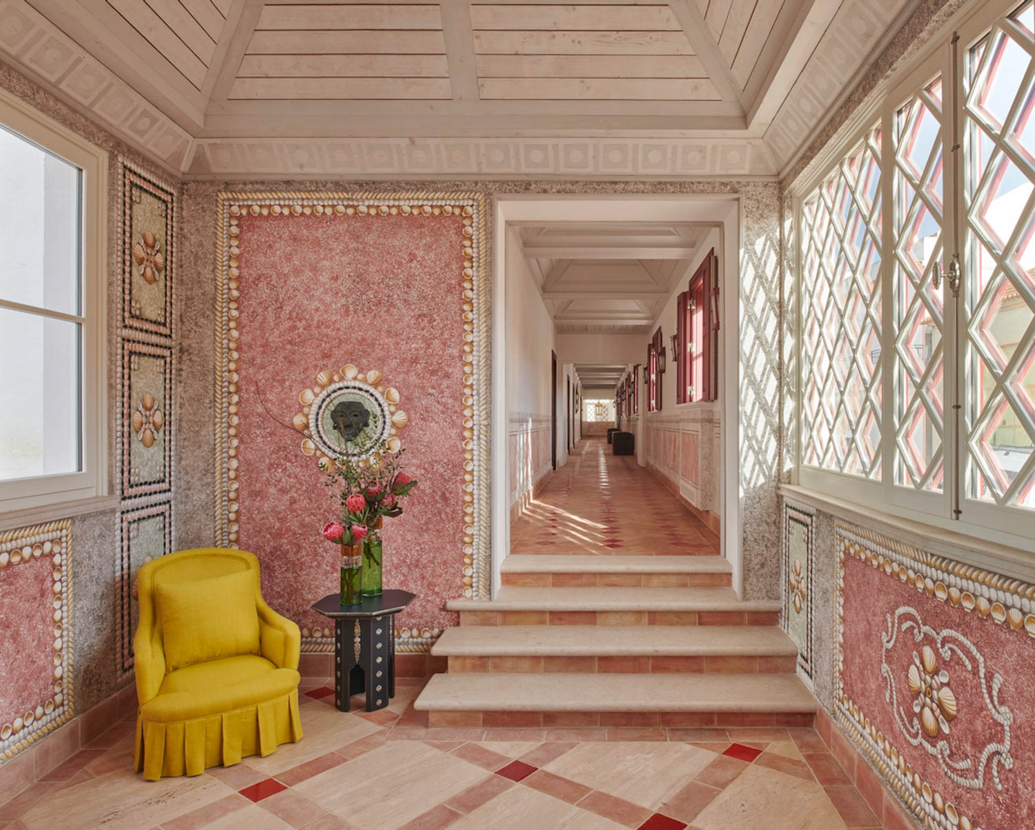 all pink hallway with bright yellow chair and stairs