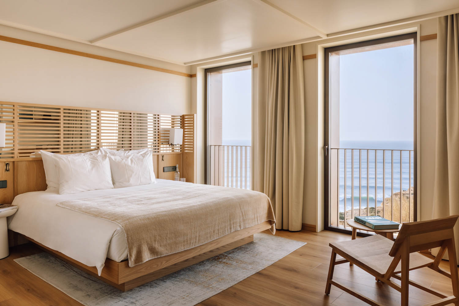 guest bedroom with white sheets and view of the sea