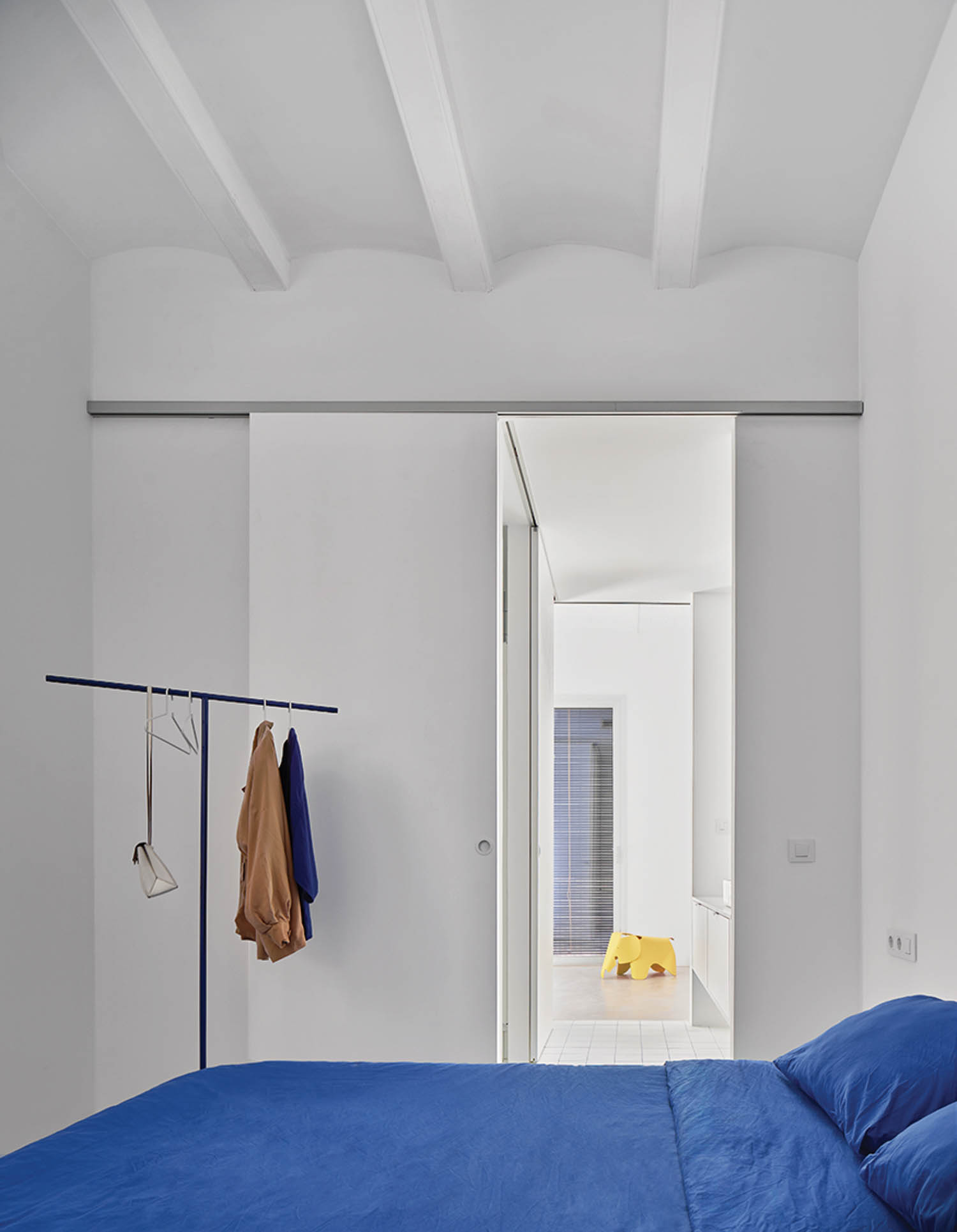 all white bedroom with blue sheets