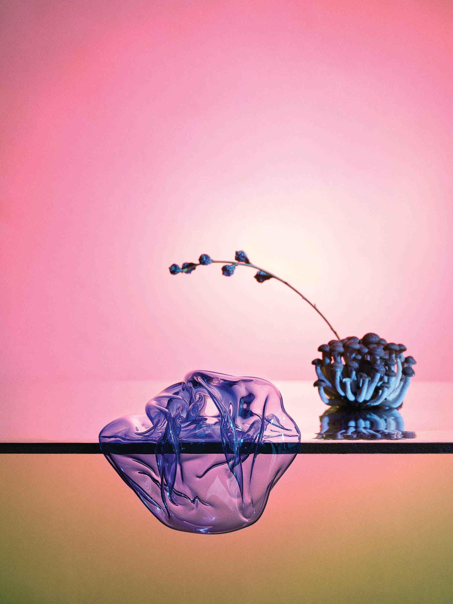 a glass sculpture on a light pink and orange ombre background